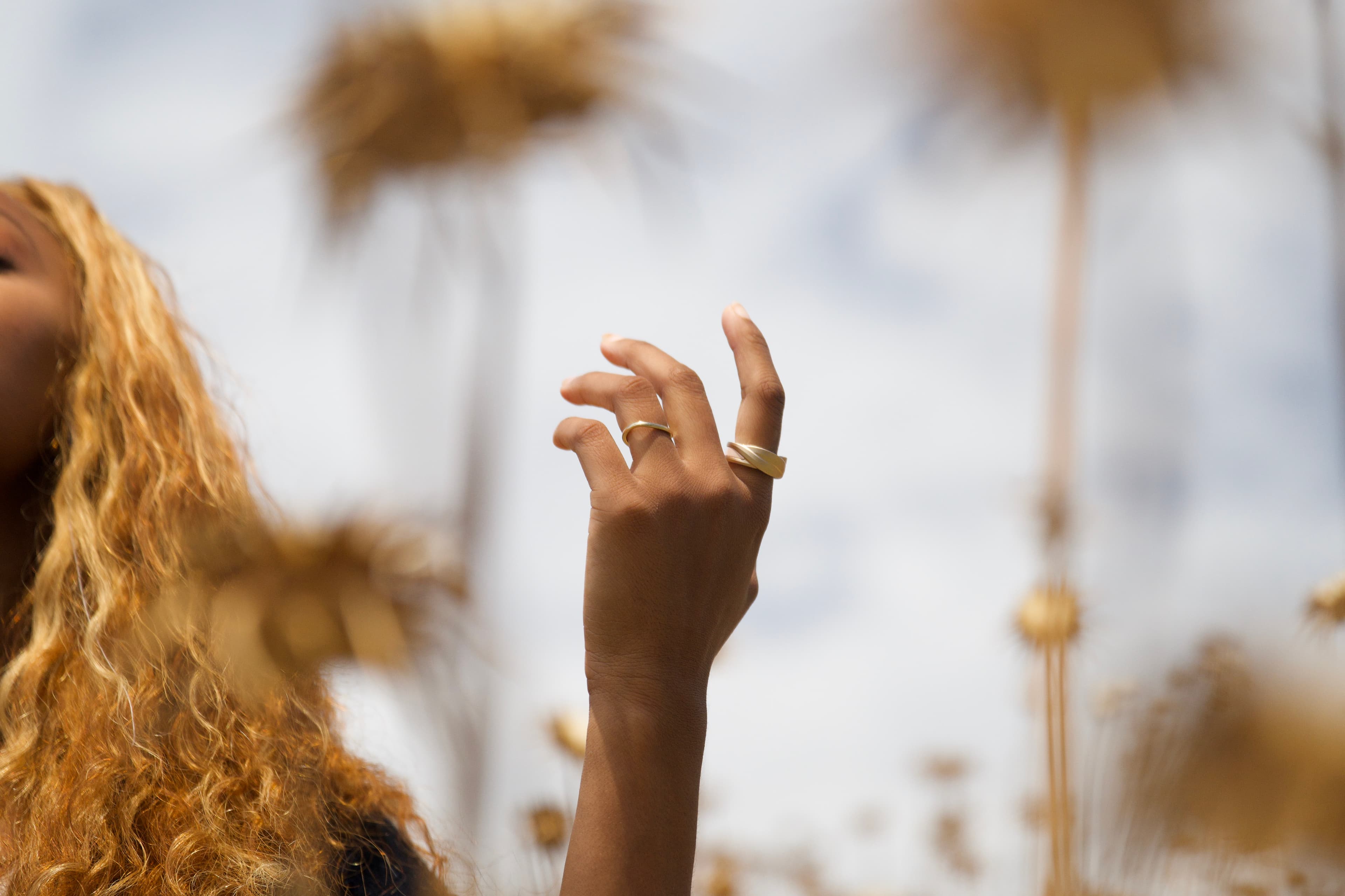 A person wearing rings in a quiet, bright space