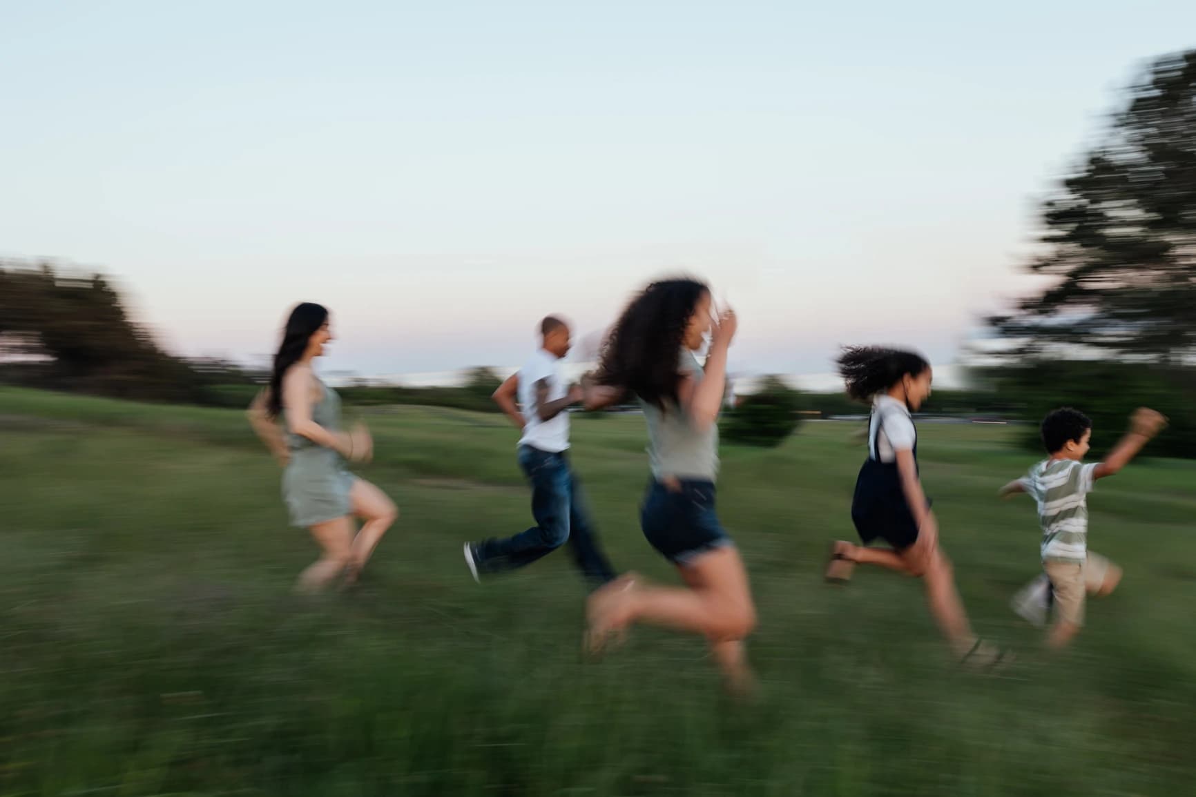 A family running together through an open field